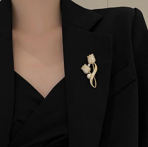 Detail of tulip brooch with sparkling rhinestones and pearl on black blazer lapel