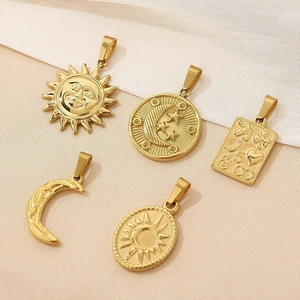Detail of celestial gold pendants including sun, moon and star designs on fabric