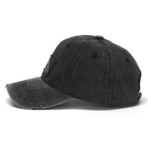 Close-up of washed gray cotton baseball cap featuring side patch and distressed brim details