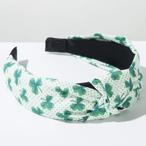 Close-up of knot headband with green shamrock clover patterns and polka dots
