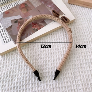Close-up of khaki knitted bow headband with 12cm width and 14cm height dimensions