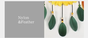Detailed view of sunflower dreamcatcher featuring green feathers and durable nylon materials