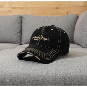 Detail der distressed schwarzen Baseballkappe mit PineCrest-Stickerei und ausgefranster Krempe
