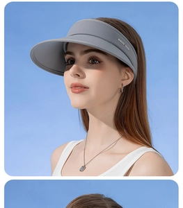 Detail view of light grey UPF50+ sun hat with wide brim and open top on female model