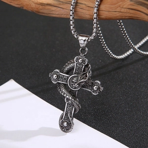 Close-up of vintage silver dragon and skull cross pendant on a square link chain