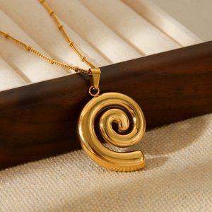 Macro detail of 18k gold plated spiral conch pendant on delicate beaded chain