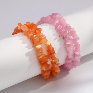 Close-up of irregular orange and pink cat eye stone bracelets on white display