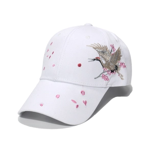 White baseball cap with crane and cherry blossom embroidery shown from a top-down view