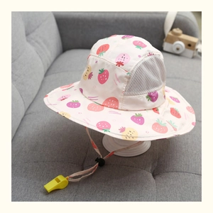 Dettaglio del cappello da sole con fragole, rete traspirante e fischietto giallo