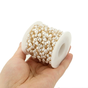 Close-up of 6mm heart-shaped pearl chain on a spool for DIY jewelry making