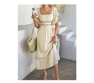 Close-up of cream square neck dress with black trim and ruffled bohemian sleeve details