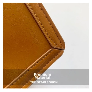 Detailed close-up of brown leather texture and double stitching on a modern square bag