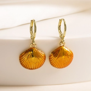 Vintage 18K gold plated shell earrings with orange enamel on a white textile background