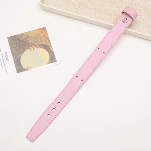 Detailed view of pink faux leather phone wrist strap with silver metal ring and stitching