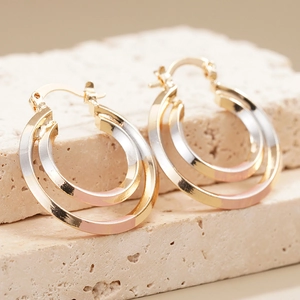 Three-tone triple hoop earrings in gold, silver, and rose gold with polished finish