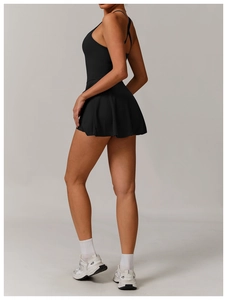 Detail of cross-back straps and pleated hem on black tennis dress with built-in shorts
