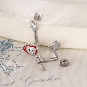 Cute red enamel apple cartilage earrings with zircon stone on marble surface