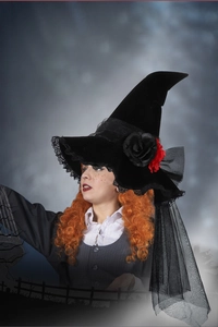 Detailed view of gothic witch hat with red roses and velvet lace texture