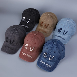 Detail of embroidered CU letters and Conquer Vanquish text on washed denim baseball caps