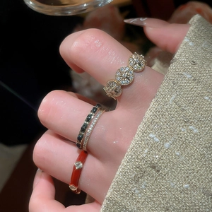 Detail of stacked 14k gold-plated rings with enamel and zircon on a hand in close-up