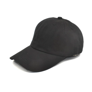 Detailed close-up of plain black cotton baseball cap with six-panel crown and curved brim
