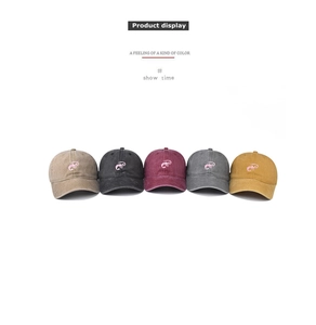 Detail of embroidered lobster on washed cotton baseball caps in five vintage colors