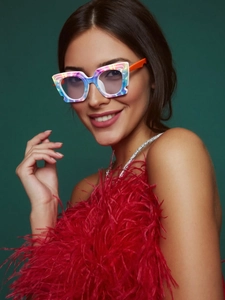 Close-up of colorful tie-dye square frames and orange temples on a fashion model
