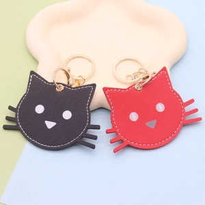 Cute cartoon cat head keychains in red and black PU leather on a paw shaped tray