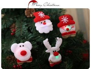 Close-up of LED glowing Christmas brooches featuring Santa and Snowman on a tree