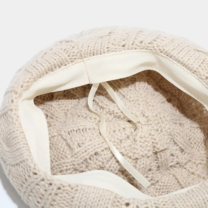 Detail of adjustable inner drawstring and woven sweatband inside the knit beret hat