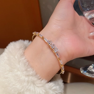 Close-up of 18K gold plated bangle featuring baguette and princess cut cubic zirconia