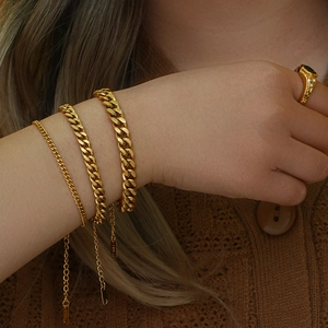 18K gold plated Cuban link bracelet set with emerald ring on model’s wrist