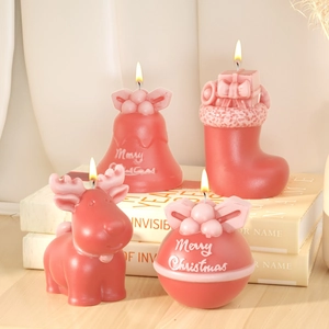 Detailed view of red Christmas themed candles with reindeer and bell designs