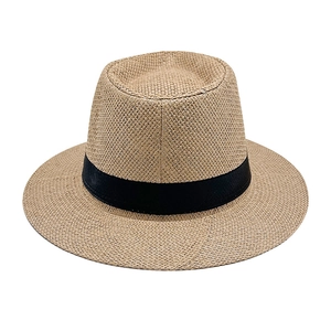 Detailed view of the woven straw sun hat texture with a wide black ribbon band