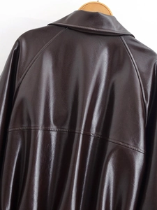 Detailed back view of dark brown faux leather cropped trench coat with waist stitching