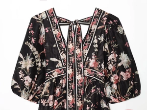 Detailed view of V-neck floral dress with puff sleeves and tie-back knot detail