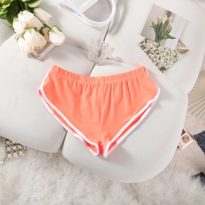 Flachbild von leuchtend orangefarbenen Sportshorts mit weißem Rand auf weichem Untergrund