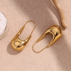 Vue détaillée de boucles d'oreilles épingle en acier doré 18 carats poli sur bois