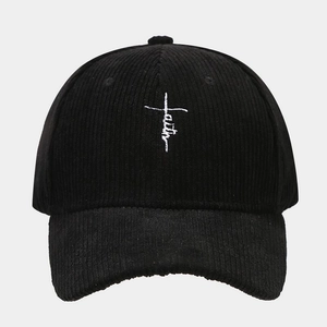 Macro detail of Faith cross embroidery on premium black corduroy texture baseball cap