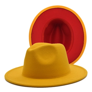 Detail of felt fedora hat featuring bold yellow exterior and vibrant red inner lining