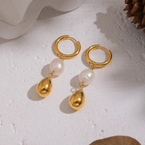 Detail of 18K gold-plated earrings with natural freshwater pearls on a white stone base