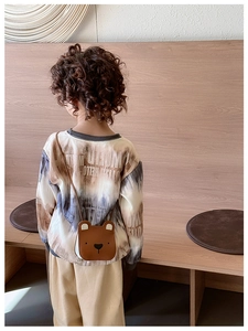 Toddler wearing a cute brown bear shaped crossbody bag made of PU leather over a tie-dye shirt