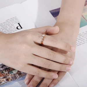 Rose gold pixel heart ring with diamond on a magazine background worn by a hand