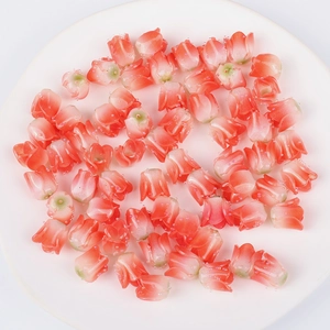 Macro view of coral red acrylic tulip flower beads with glitter detail on white plate