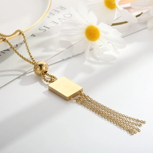 Detailed macro view of 18K gold-plated stainless steel square pendant with elegant tassels