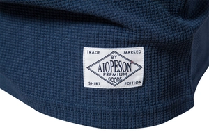 Macro detail of high-quality navy blue waffle knit texture and premium brand label