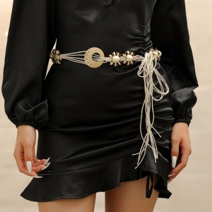 Detail of bohemian hand-woven waist rope with sunflower beads and wooden rings on black dress
