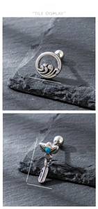 Detailed view of silver eagle studs with turquoise and boho feather charms