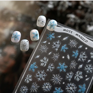 Detailed macro view of embossed winter snowflake nail stickers with blue glitter finish