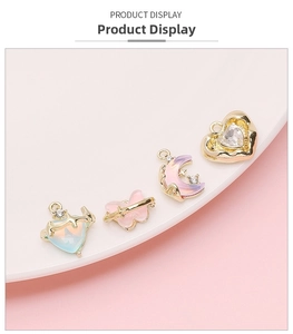 Detailed view of DIY heart and butterfly charms in gold alloy with iridescent resin
